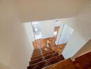 View of a staircase with wooden steps leading to a hallway and bathroom