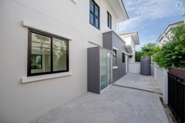 Exterior of a modern residential building with sliding glass doors and windows