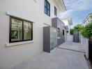 Exterior of a modern residential building with sliding glass doors and windows