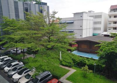 View of the residential complex with parking and greenery