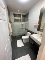 Modern bathroom with glass-enclosed shower, toilet, and sink