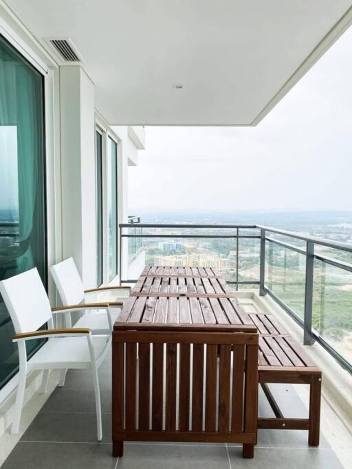 High-rise balcony with a wooden table set and scenic view
