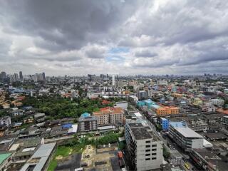 Aerial view of an urban cityscape with multiple buildings and cloudy sky