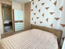 Modern bedroom with patterned wall and ensuite bathroom