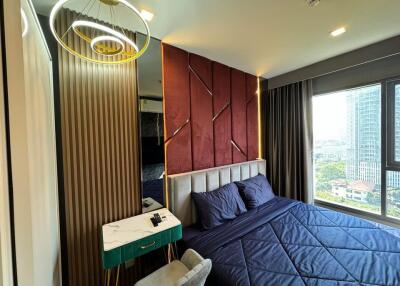 Modern bedroom with large window, decorative headboard, and cozy bed setup.