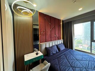 Modern bedroom with large window, decorative headboard, and cozy bed setup.