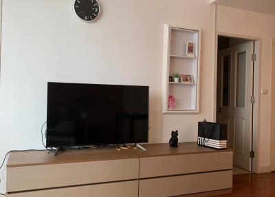 Living room with TV console and wall clock