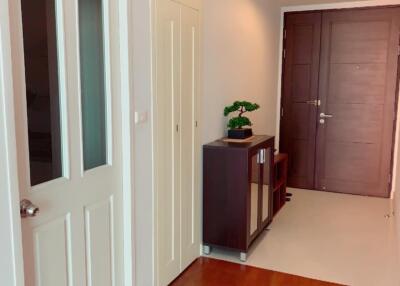 A hallway with wooden flooring and a small cabinet