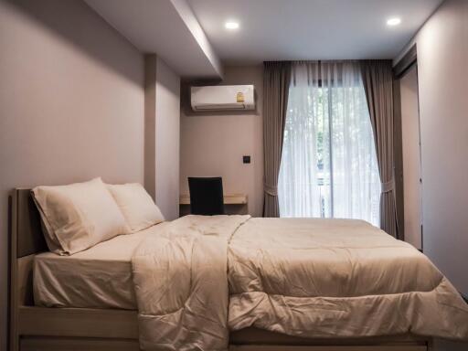 Bedroom with a large bed and a window with curtains