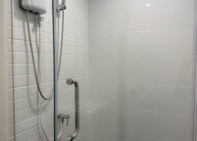 Shower area with white tiles and safety bar