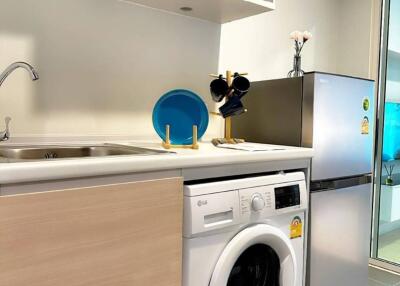 Modern kitchen with washing machine and refrigerator