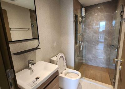 Modern bathroom with a shower, sink, and toilet