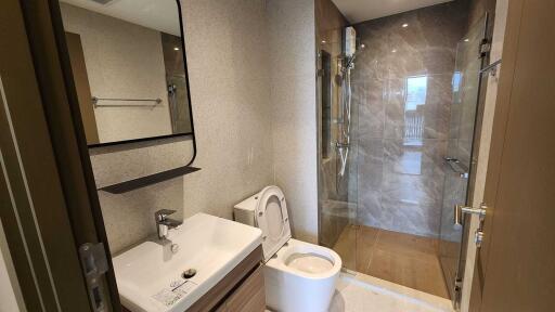 Modern bathroom with a shower, sink, and toilet