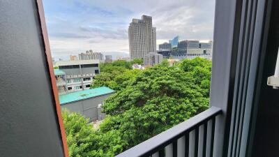 View from the balcony of the city skyline with greenery in the foreground.