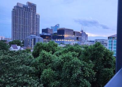 City skyline view with trees in the foreground during dusk