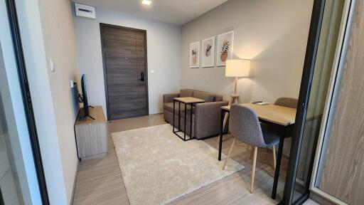 Modern living room with a sofa, TV, and a small desk.