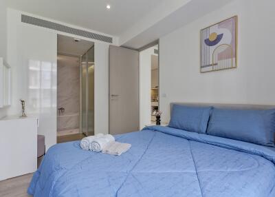 Modern bedroom with blue bedding and attached bathroom
