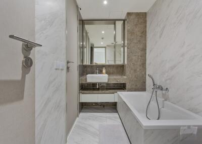Modern bathroom with marble walls, bathtub, and sink