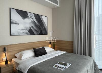 Modern bedroom with wooden accents and large abstract painting above the bed
