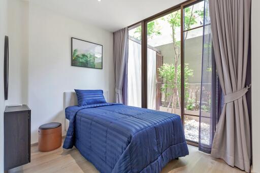 Bright bedroom with large window and single bed