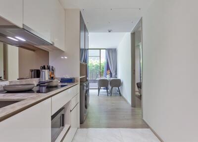 Modern kitchen leading into a dining area with natural light.