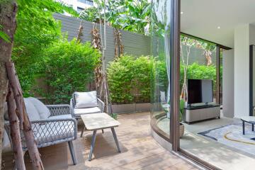 Bright backyard lounge area with seating and greenery