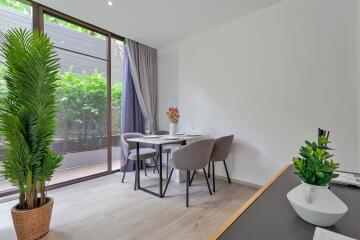 Modern dining room with a large window and greenery visible outside