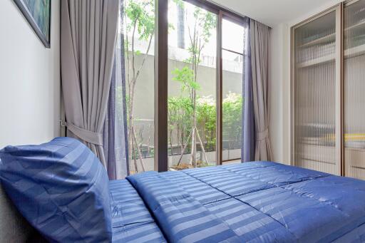 Bedroom with large windows and blue bedding