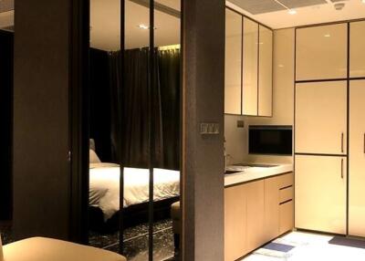 Modern bedroom and kitchen with built-in appliances and glass partition