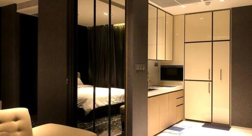 Modern bedroom and kitchen with built-in appliances and glass partition