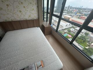 Bedroom with a large window and city view