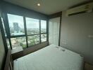 Bedroom with large windows and city view