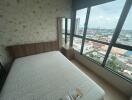 Bedroom with a large window and city view