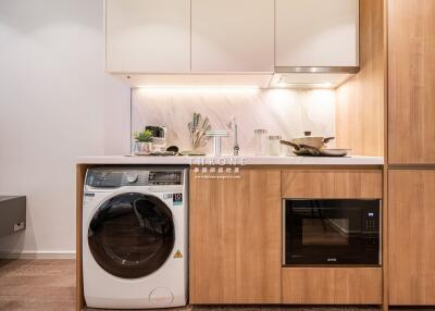 Modern kitchen with built-in appliances including washing machine and microwave