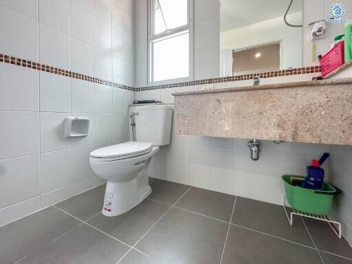Clean bathroom with tiled walls and floor, toilet, and a sink