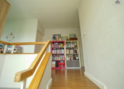Hallway with wooden stairs and built-in bookshelf