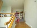 Hallway with wooden stairs and built-in bookshelf