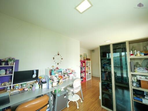 A well-lit study room with a desk, chair, and shelves