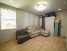 Living room with beige sofa, grey chair, and various storage options