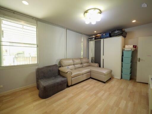 Living room with beige sofa, grey chair, and various storage options