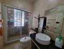 Bathroom with modern sink, shower, and decorative elements