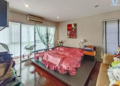 Spacious bedroom with modern decor, large bed, and balcony access