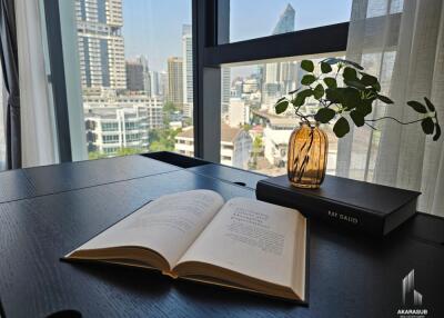 City view from a modern living room with a book and decorative plant