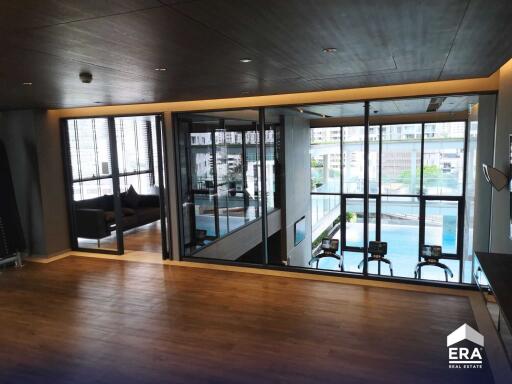 Modern indoor gym with a view of the pool and cityscape