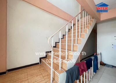 Staircase in a residential building with clothes hanging on the railing