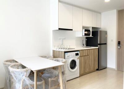 Modern kitchen area with wash machine and dining table