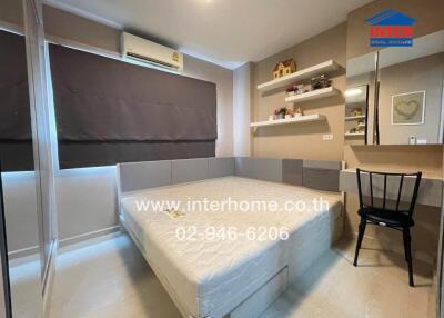 Modern bedroom with a bed, air conditioning, shelves, wall art, and study area