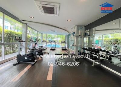Modern fitness room with gym equipment and large windows
