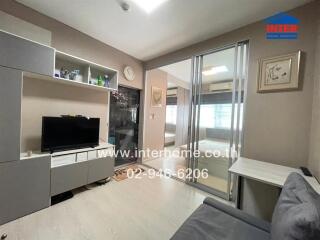 Living room with a TV, grey cabinet, and sliding glass doors