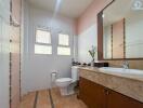 Modern bathroom with a large mirror and window.